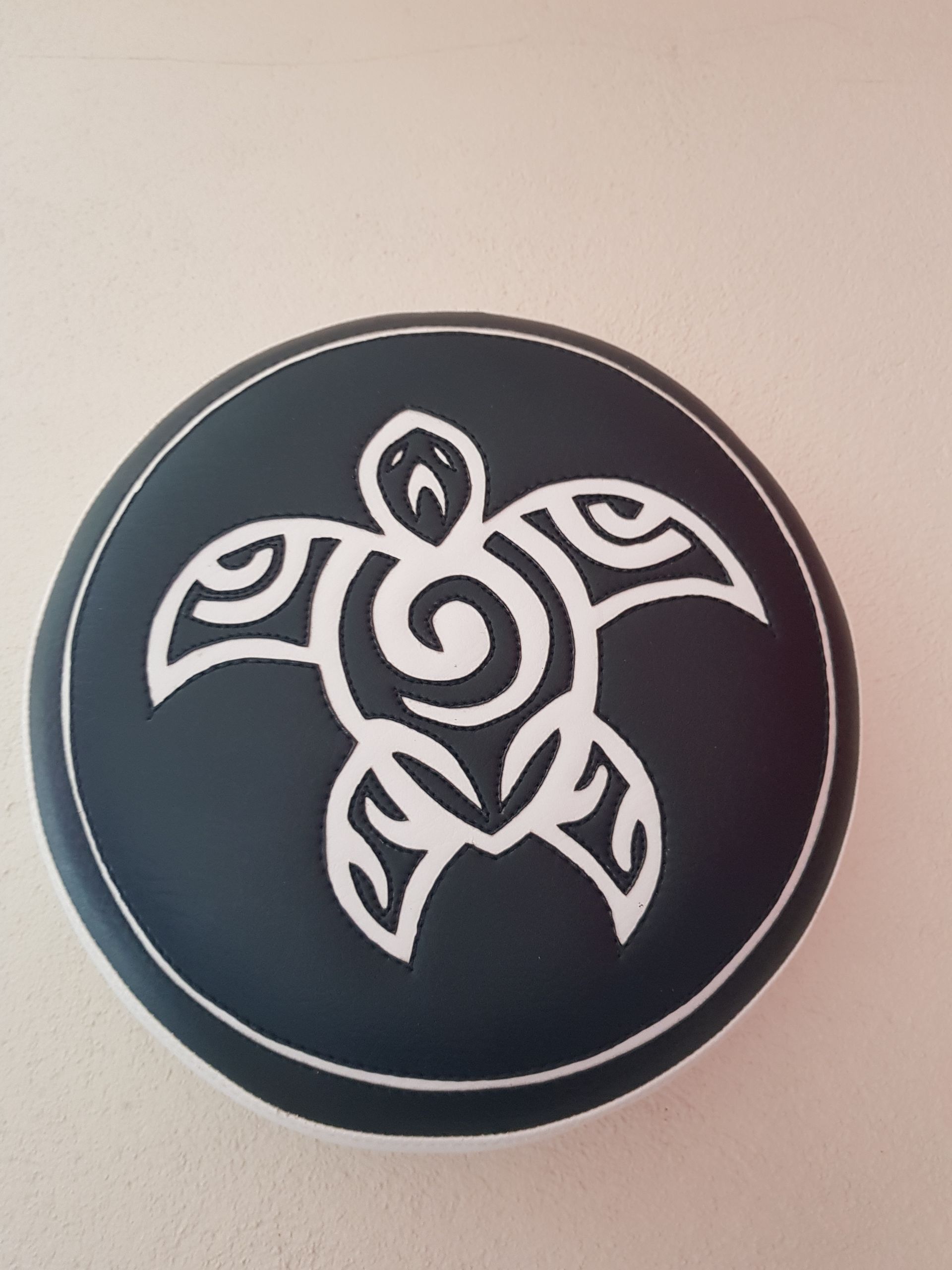 Un cercle noir avec une tortue blanche dessus