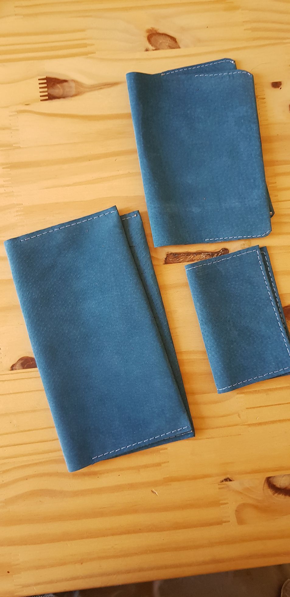Trois serviettes bleues sont posées sur une table en bois.