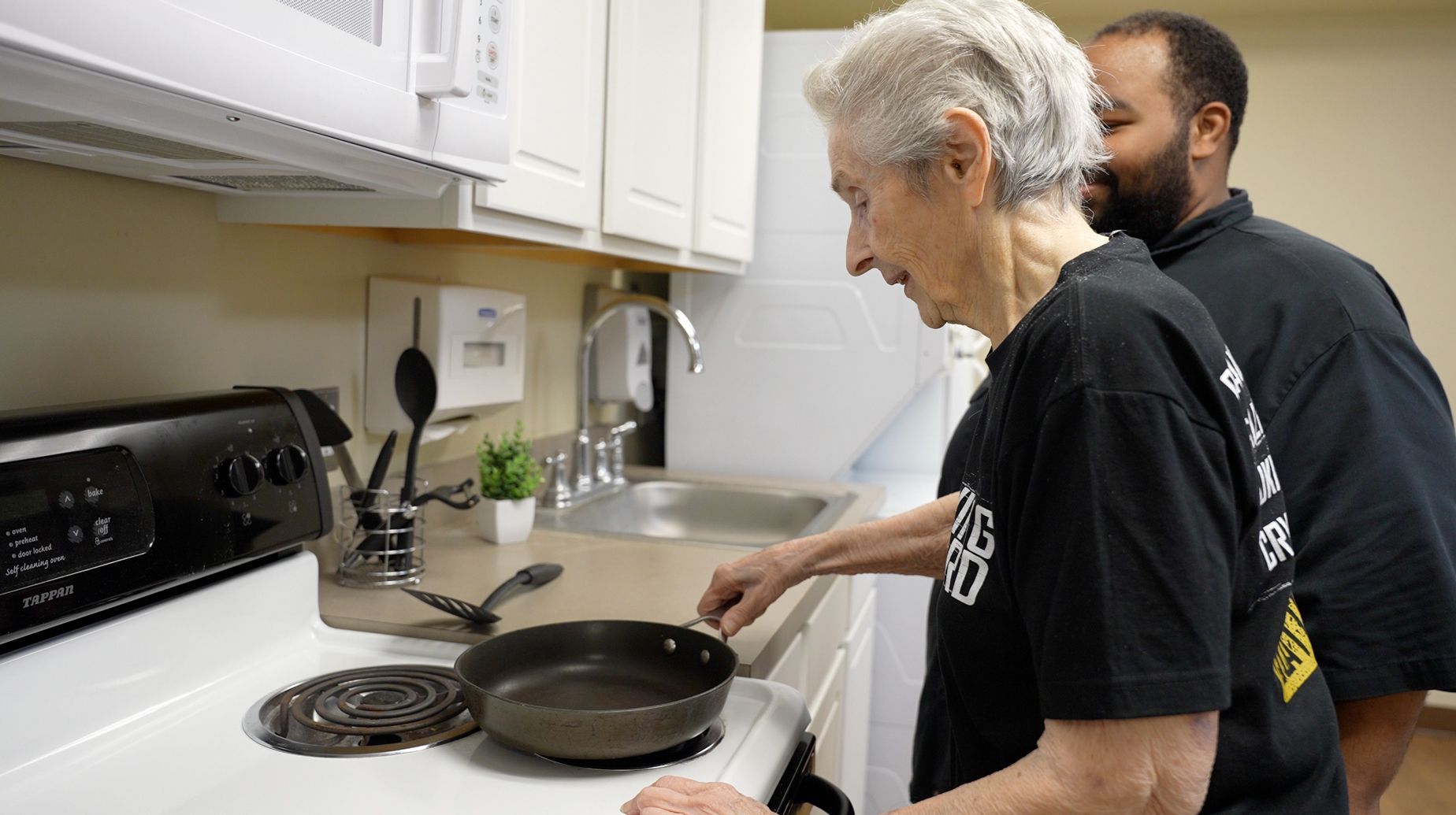 A caregiver assisting a resident in the kitchen
