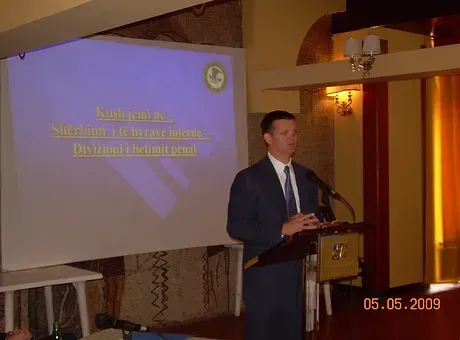 A man in a suit and tie is giving a presentation