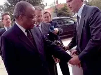 A group of men in suits and ties are shaking hands.