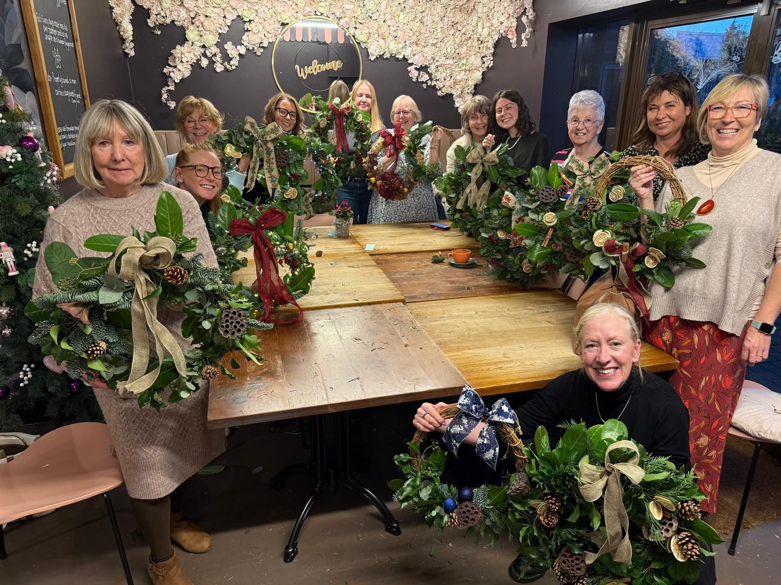 A group of people at a floral wreath making class fundraiser