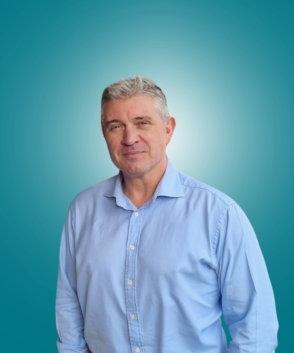 A bald man in a blue shirt is smiling for the camera.