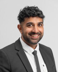 A man in a suit and tie is smiling for the camera.