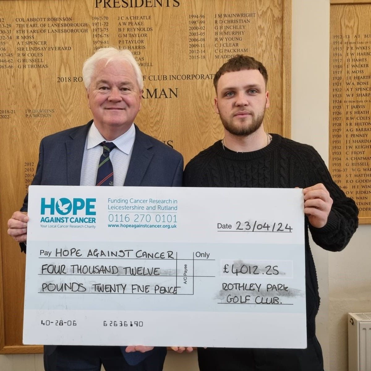 Two men holding a cheque for hope against cancer