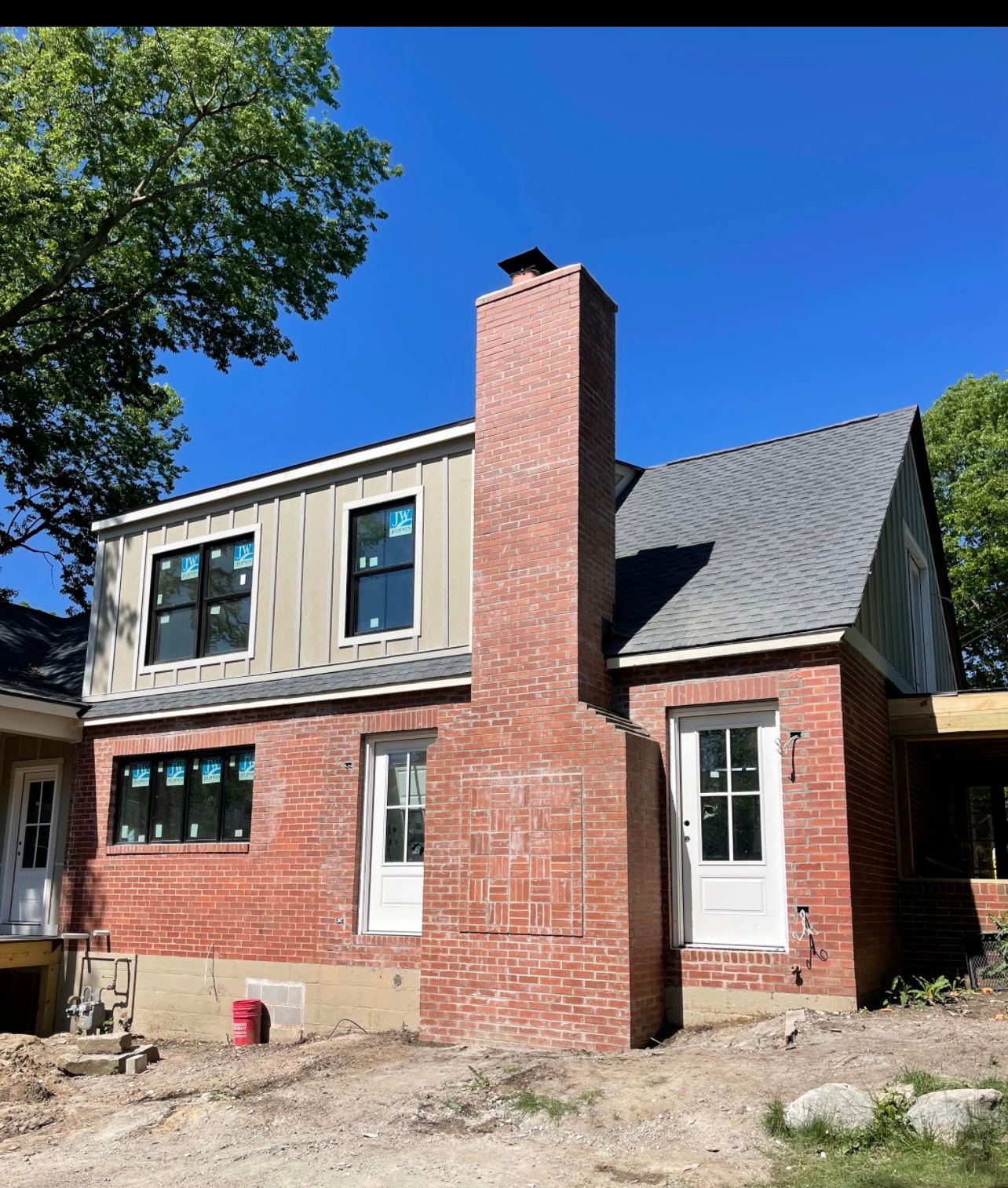 A brick house with a chimney on the side of it.