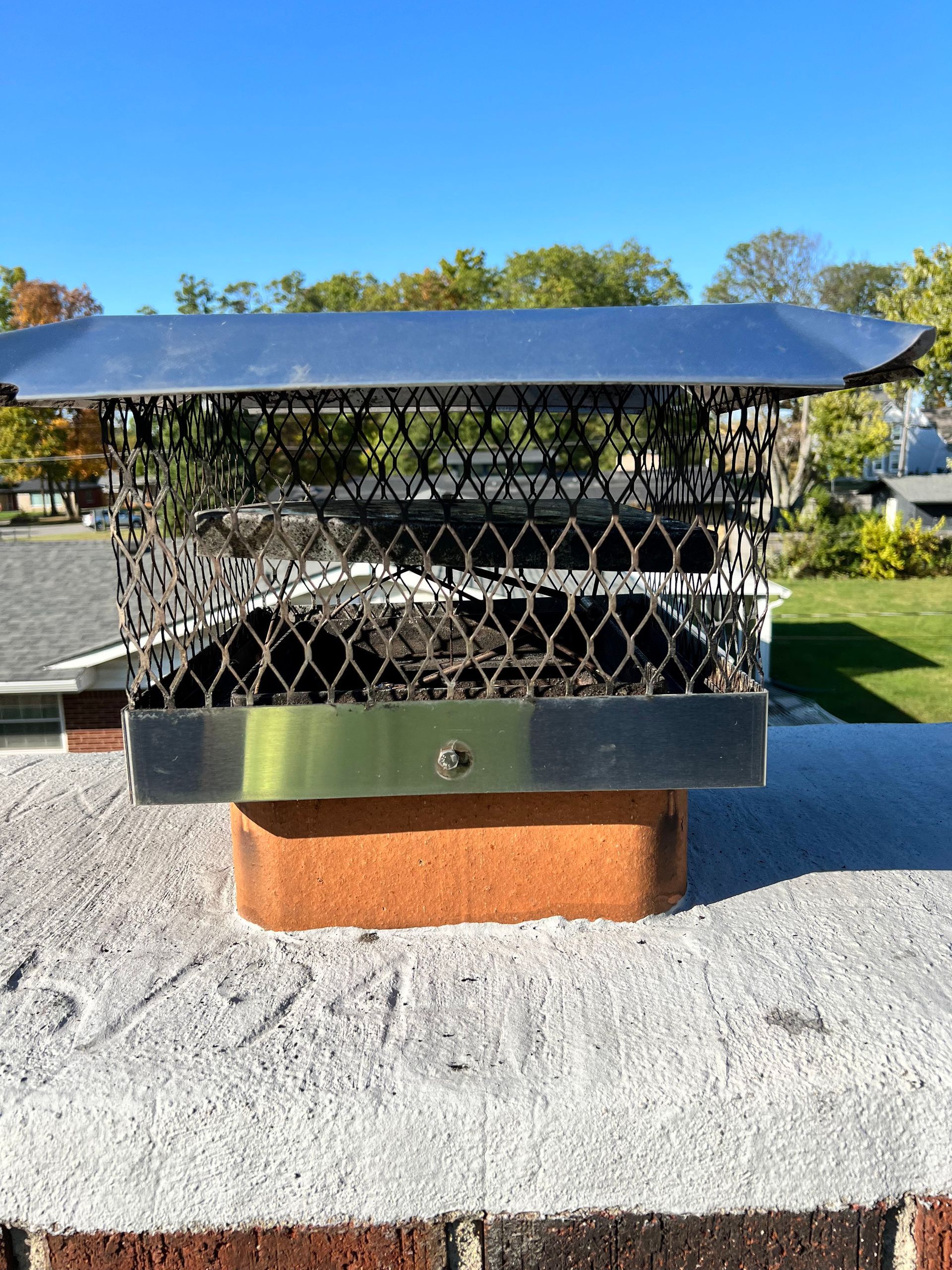 A chimney cap is sitting on top of a brick wall.
