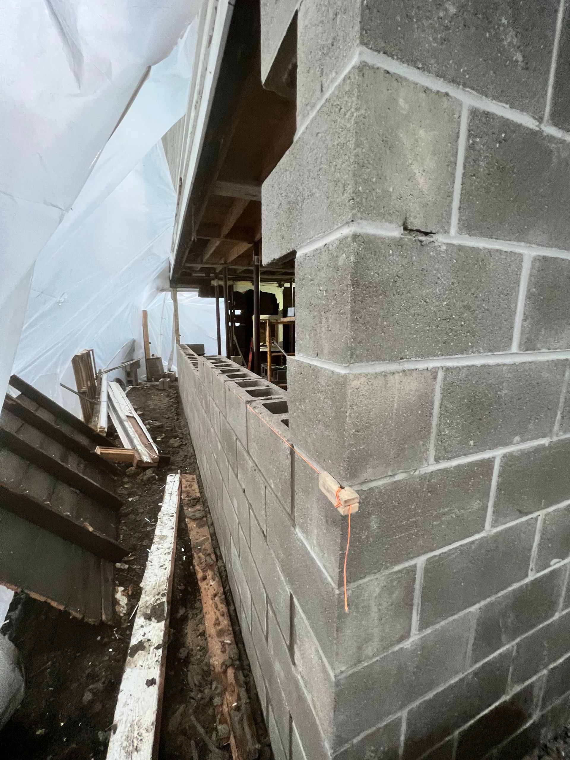 A brick wall is being built on the side of a building.