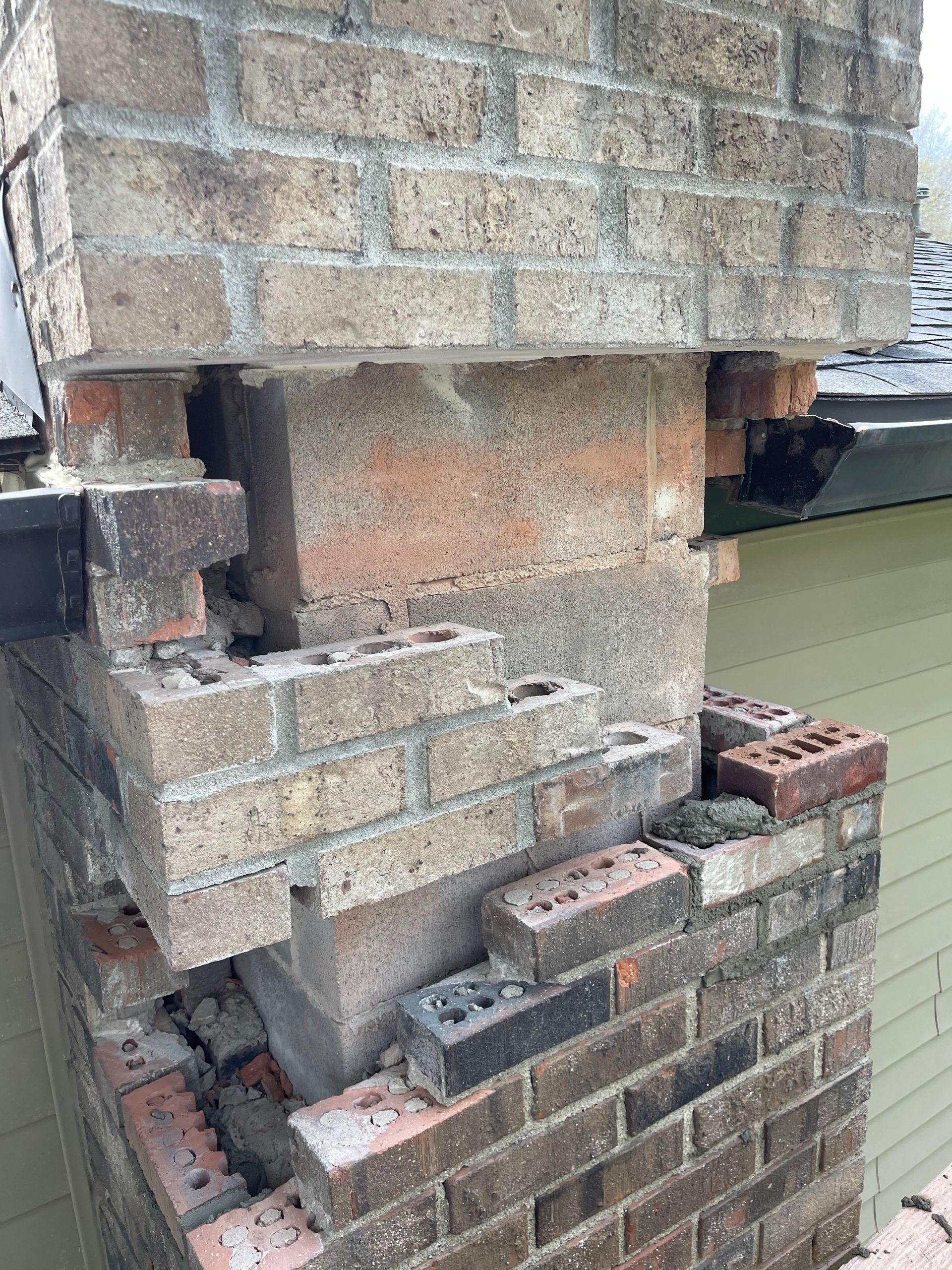 A close up of a brick chimney with a hole in it.