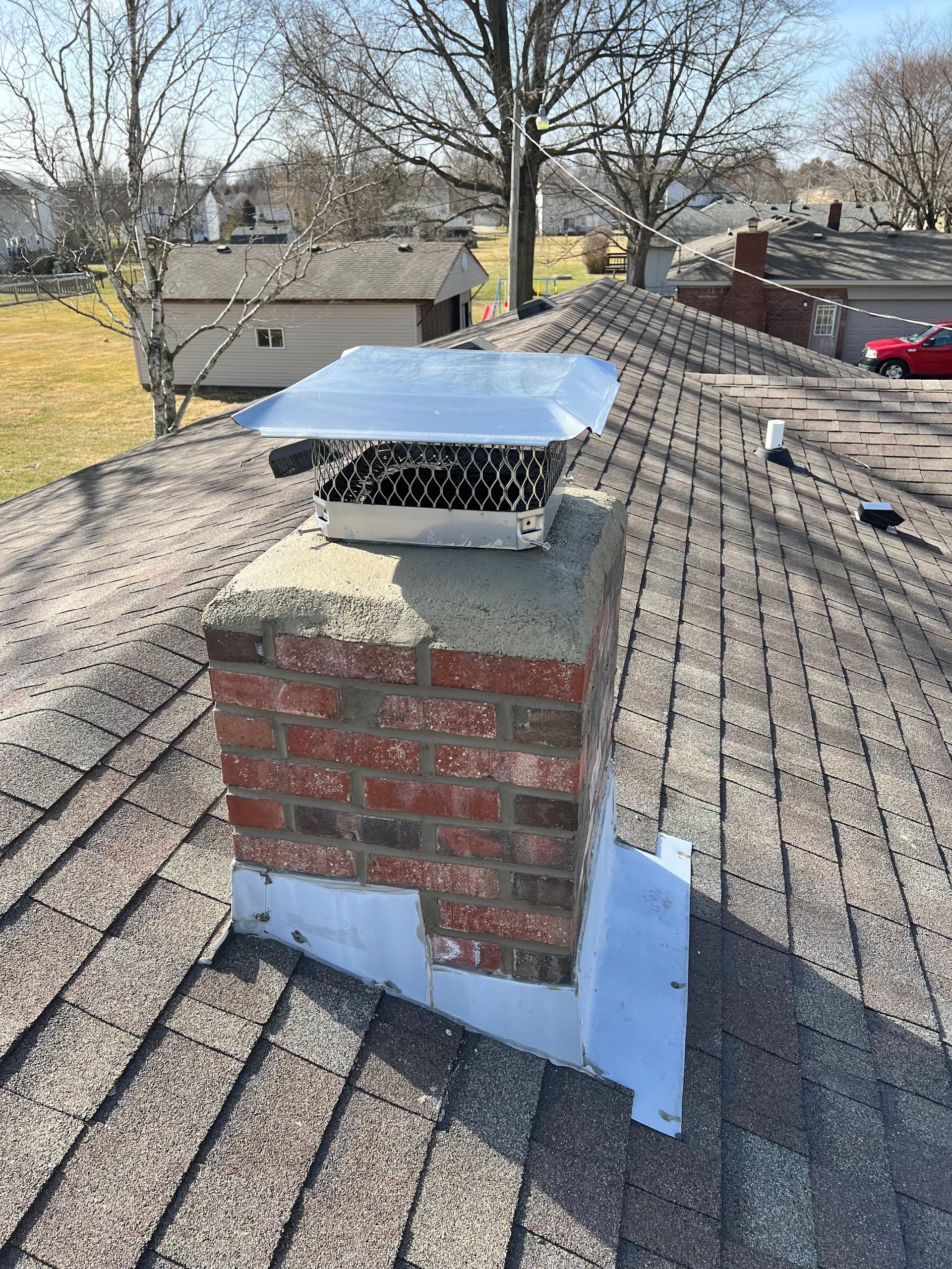 A brick chimney is sitting on top of a roof.