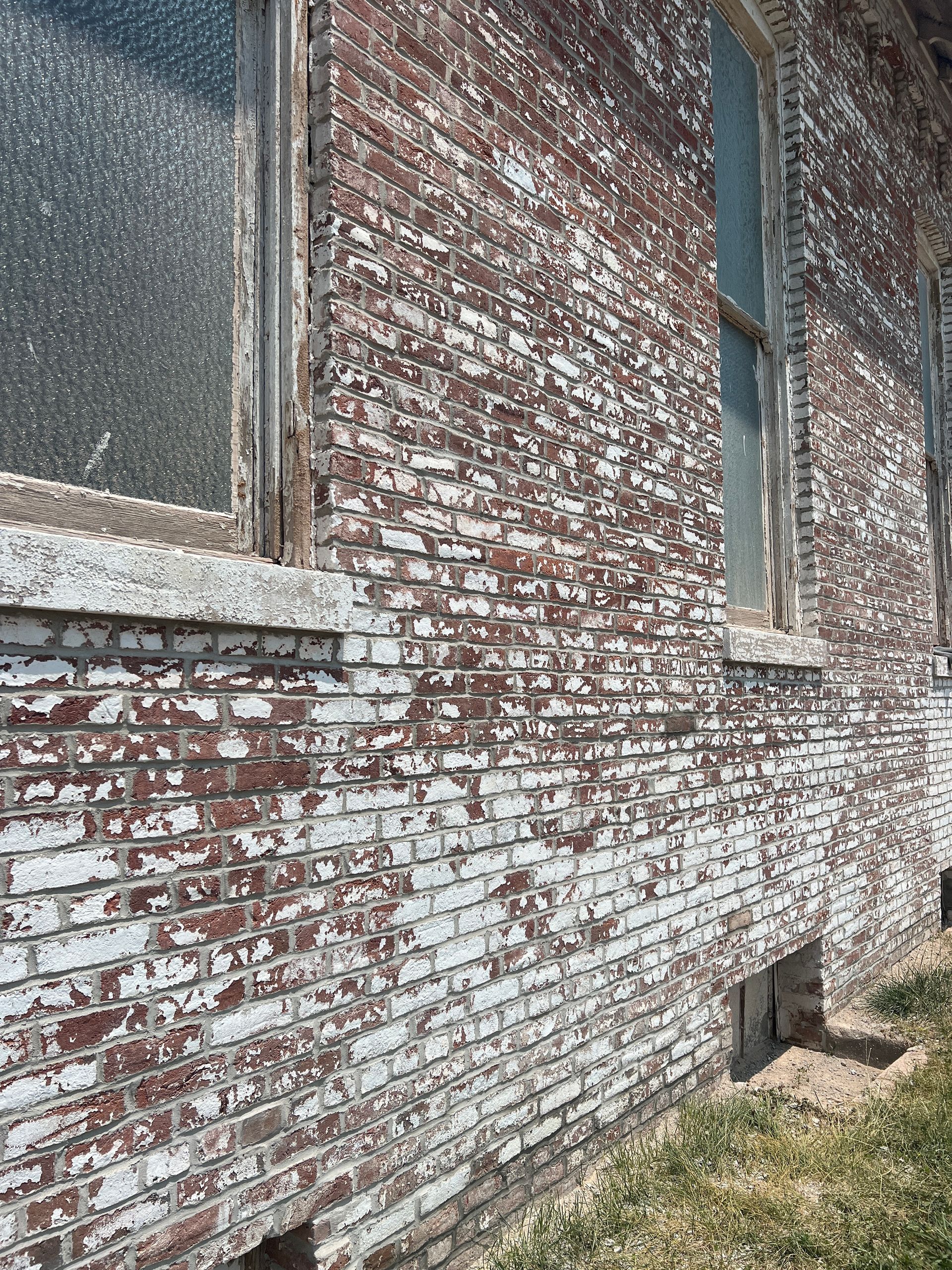 A close up of a brick wall with a window on it.