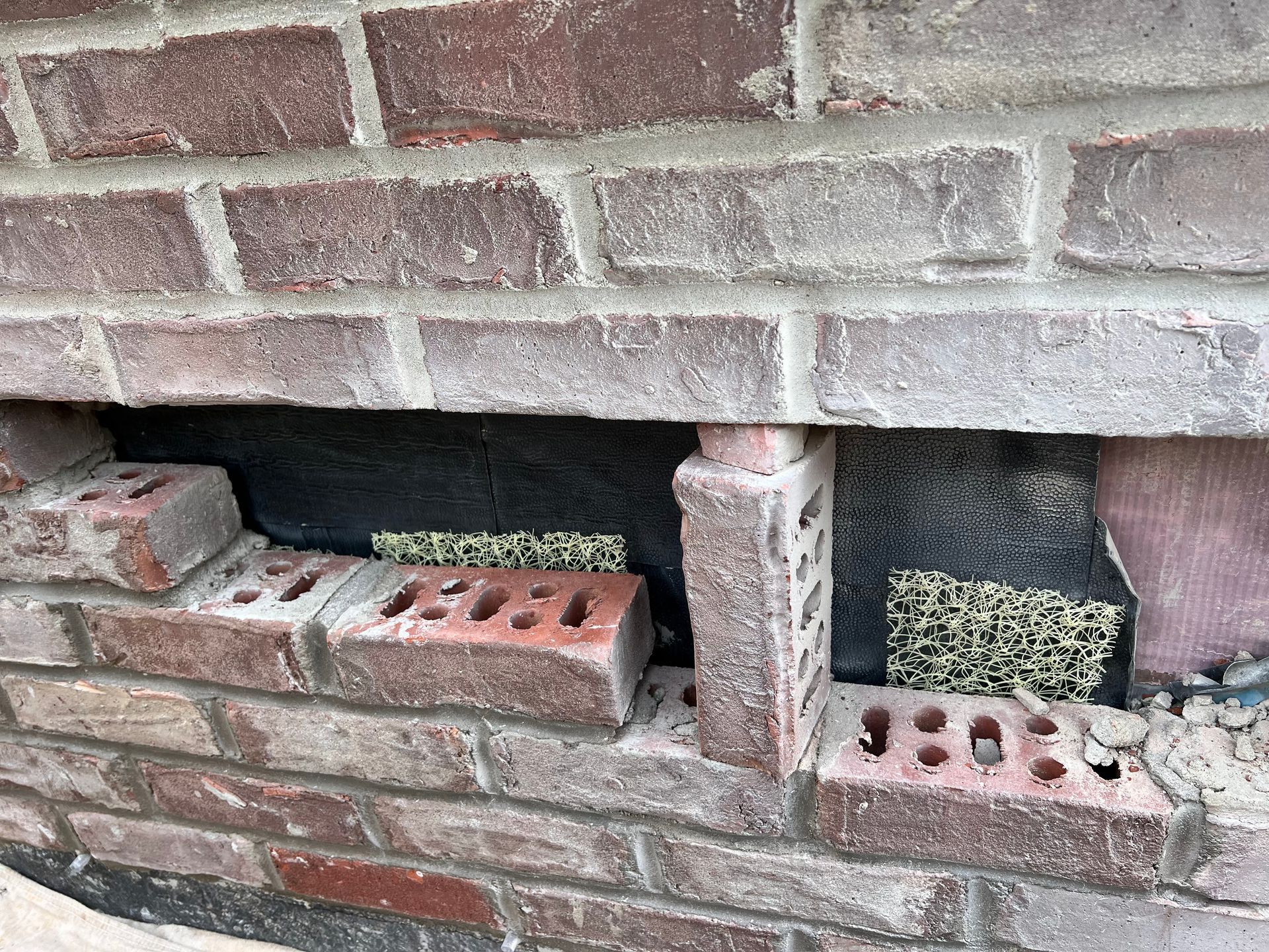 A close up of a brick wall with bricks stacked on top of each other.