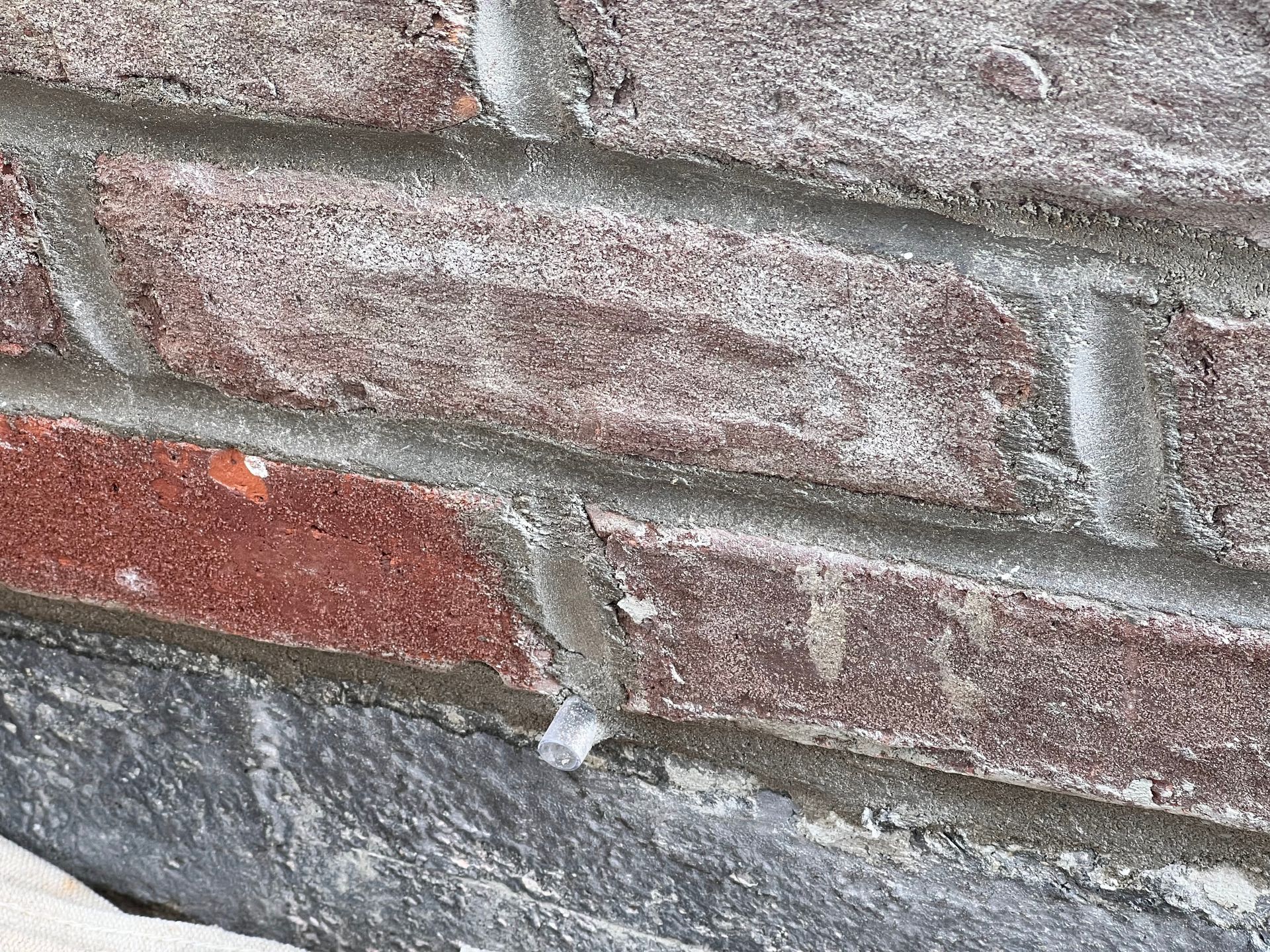 A close up of a brick wall with a few bricks missing.