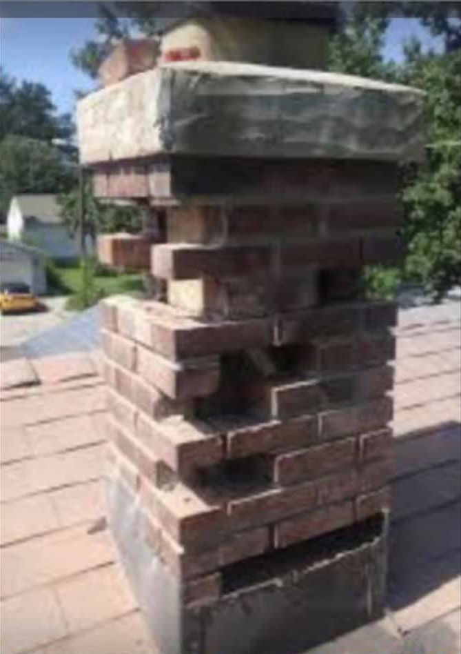 A brick chimney is sitting on top of a roof.
