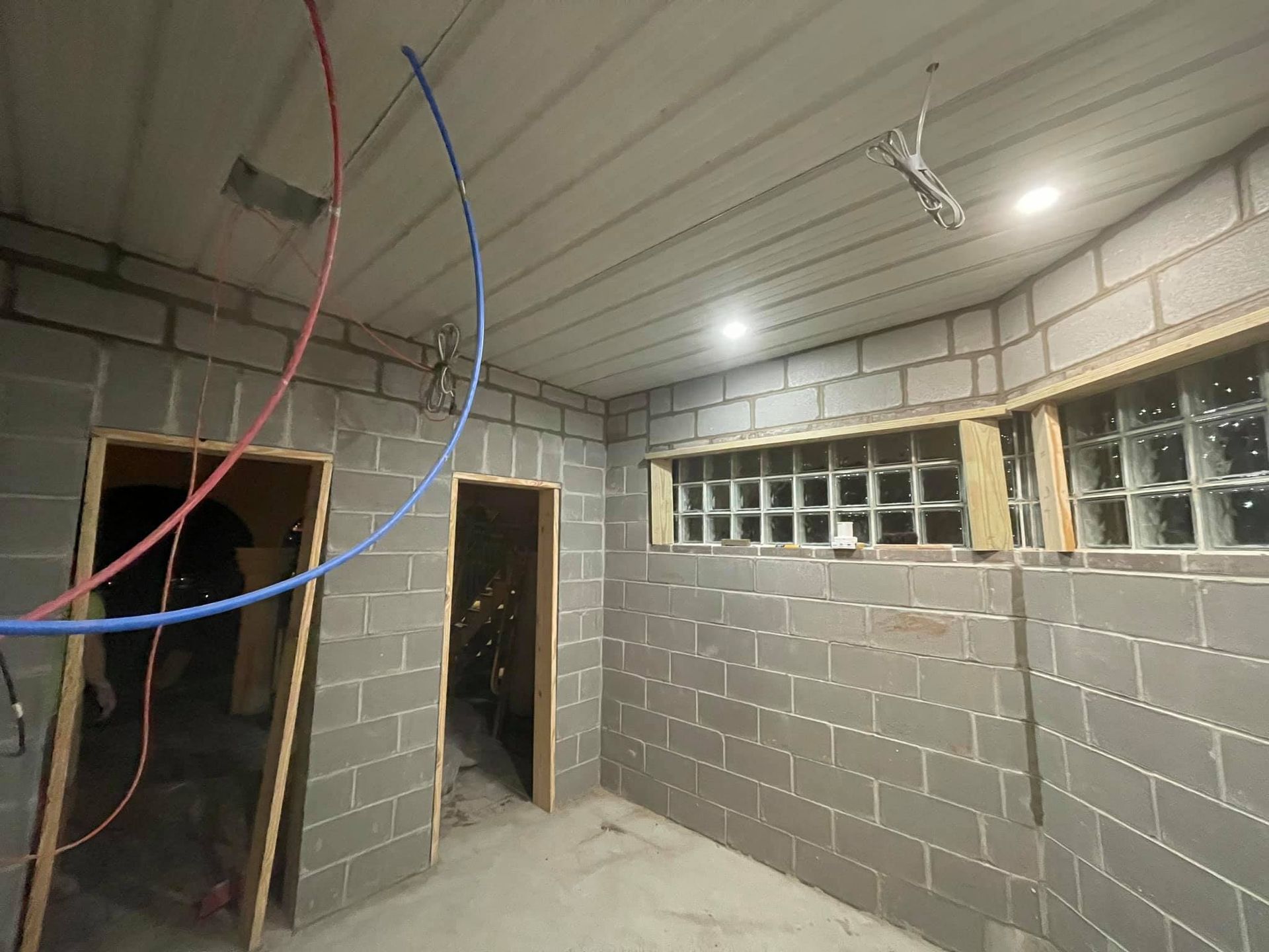 A room with brick walls and a ceiling with wires hanging from it.