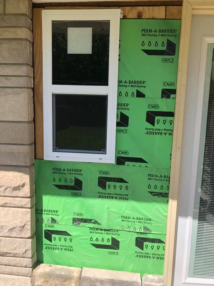 A window is being installed on the side of a house.