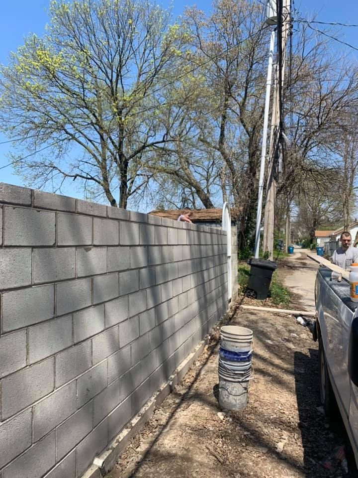 A brick wall is being built next to a truck.