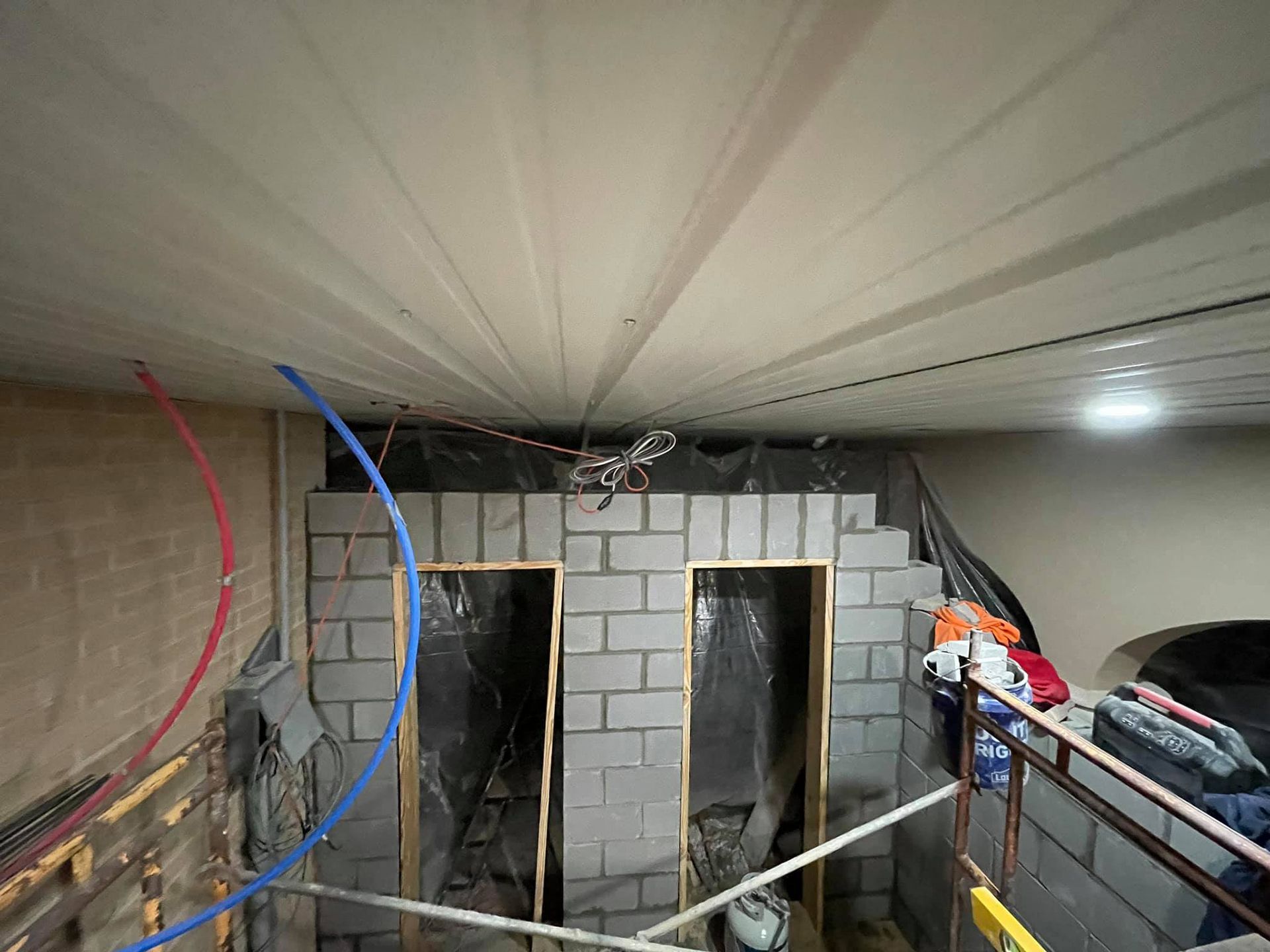 A room that is being built with a lot of wires hanging from the ceiling