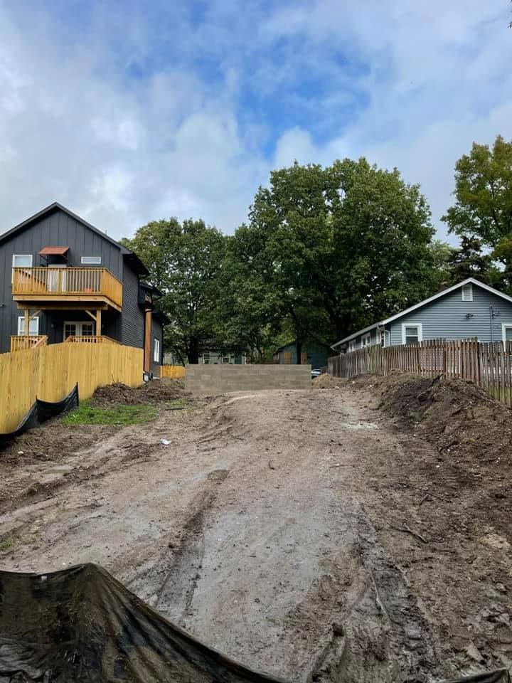 Two houses are sitting next to each other on a dirt road.