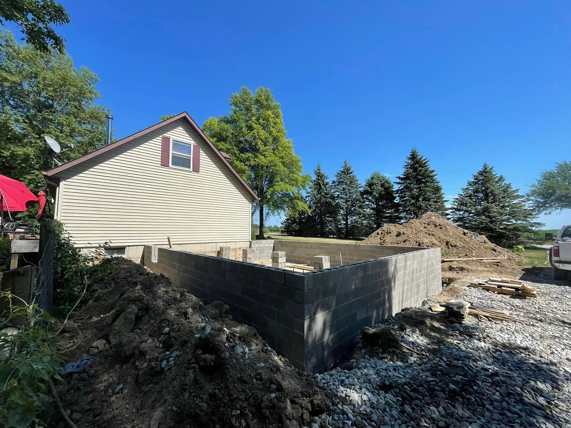 A house under construction with a pile of dirt in front of it