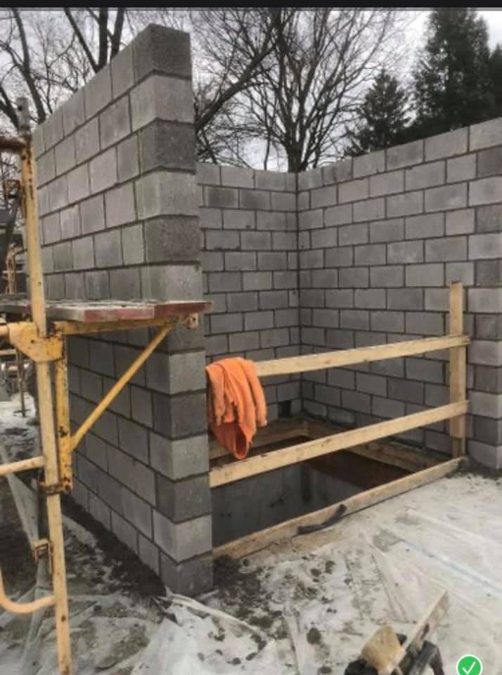 A building is being built with bricks and a wooden fence.