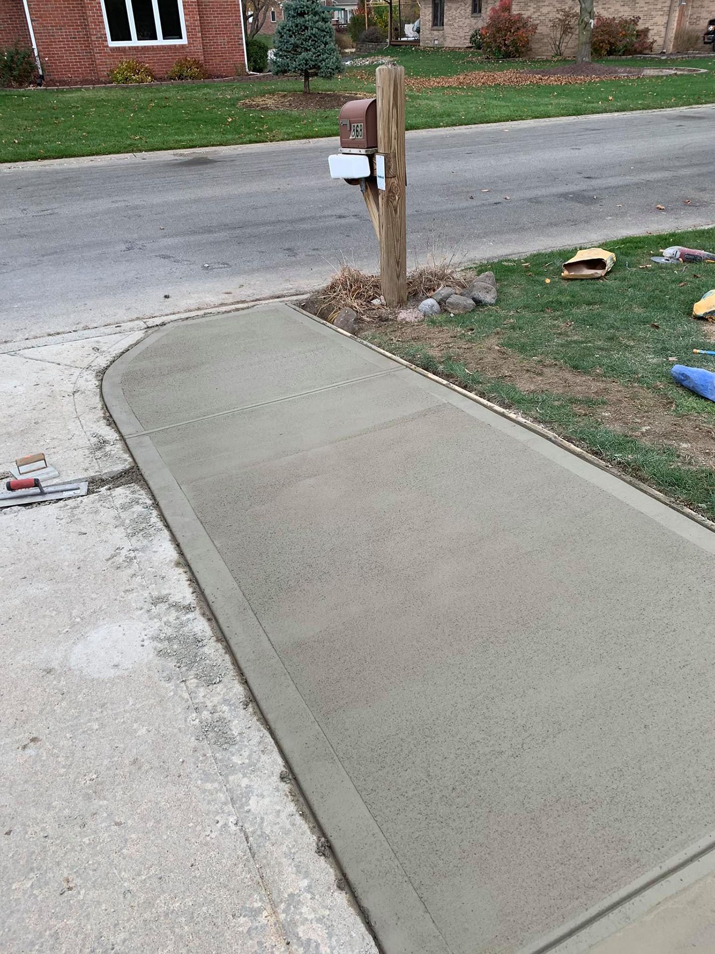 A concrete sidewalk is being built next to a mailbox.