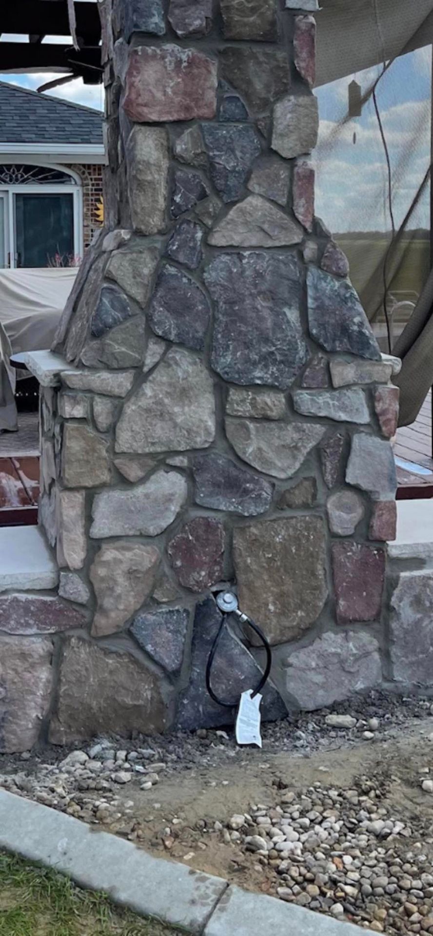 A stone chimney in backyard.
