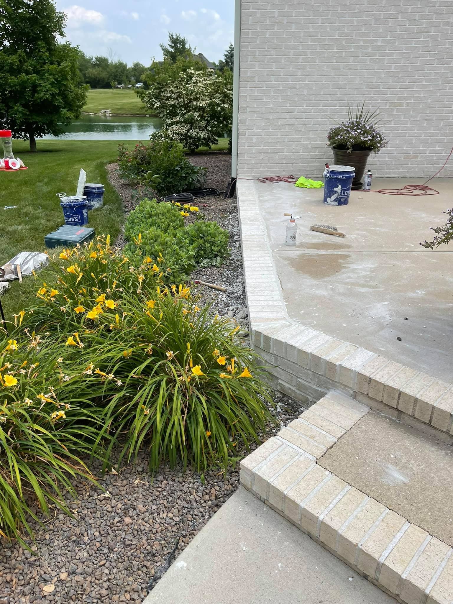 A patio is being painted in front of a house.