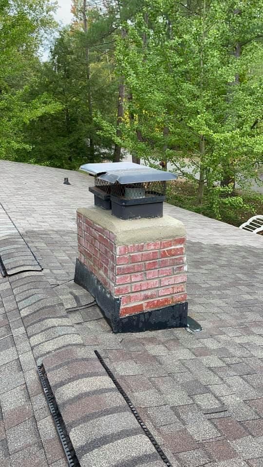 A chimney is sitting on top of a brick roof.