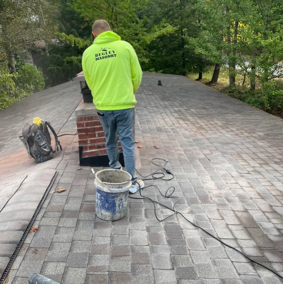 A man in a neon green jacket is standing on a brick roof.