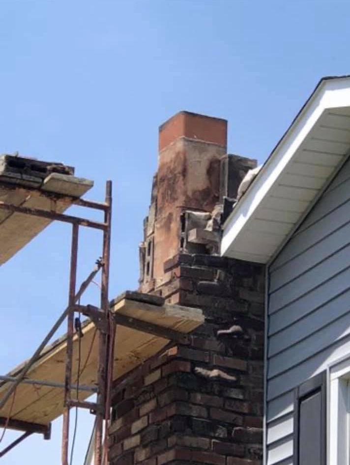A chimney is being repaired on the side of a house.