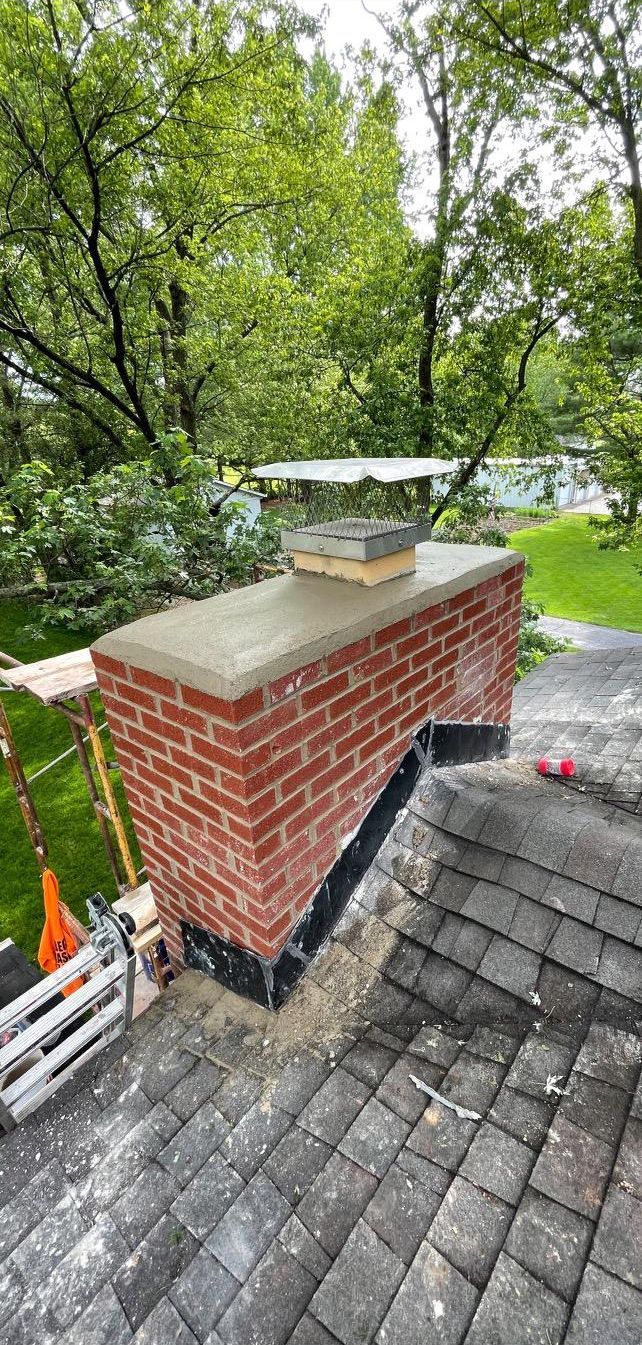 A brick chimney is sitting on top of a brick roof.
