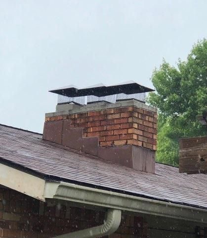 A brick chimney on top of a roof of a house.