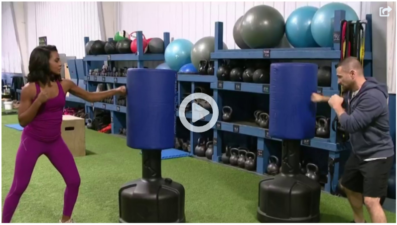 A man and a woman are boxing in a gym
