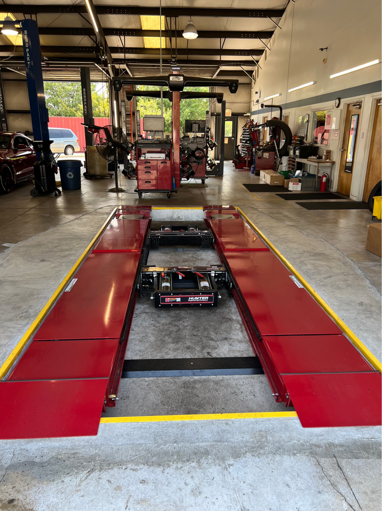 A red lift is sitting in the middle of a garage.