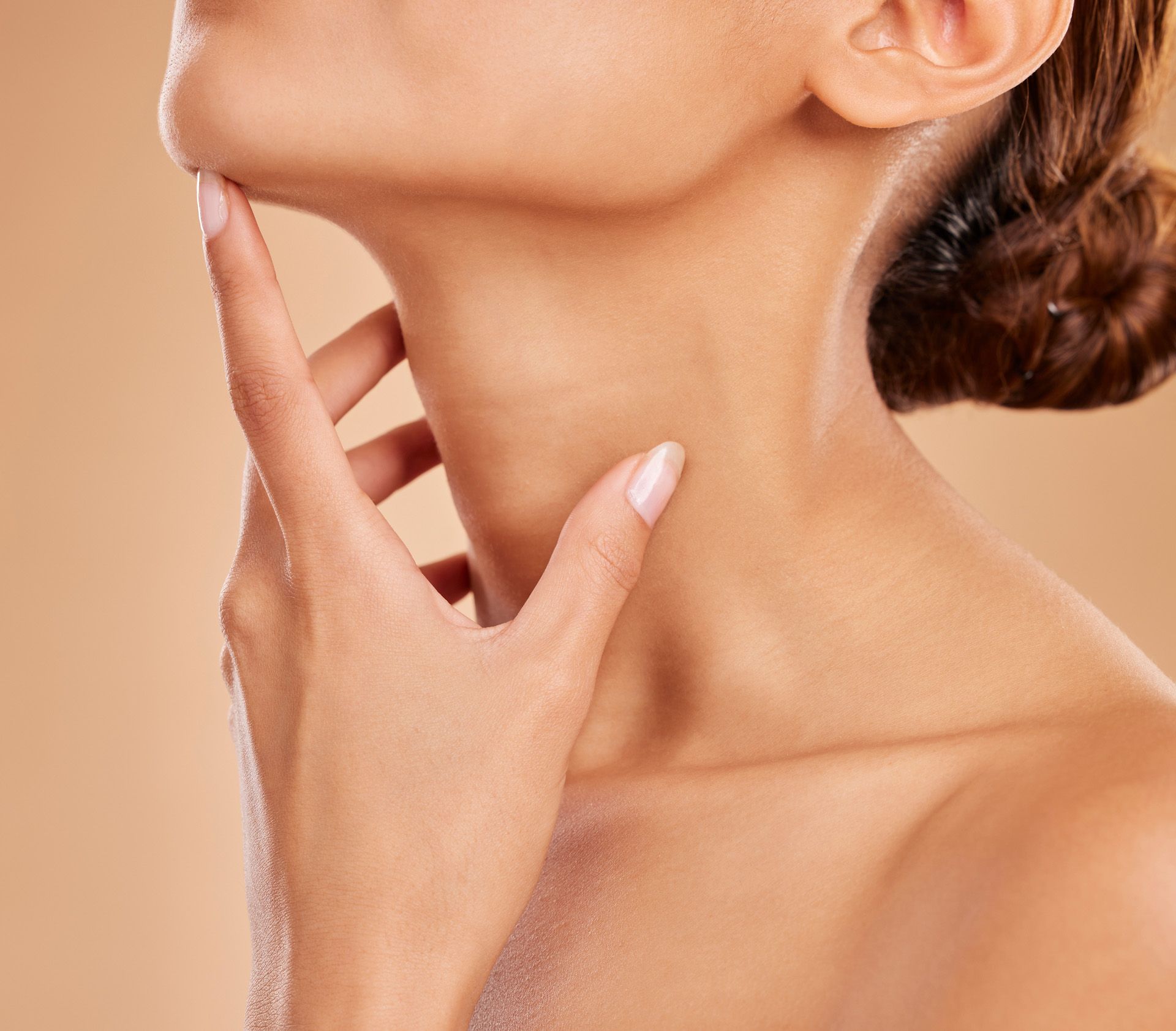 A close up of a woman 's neck with her hand on it
