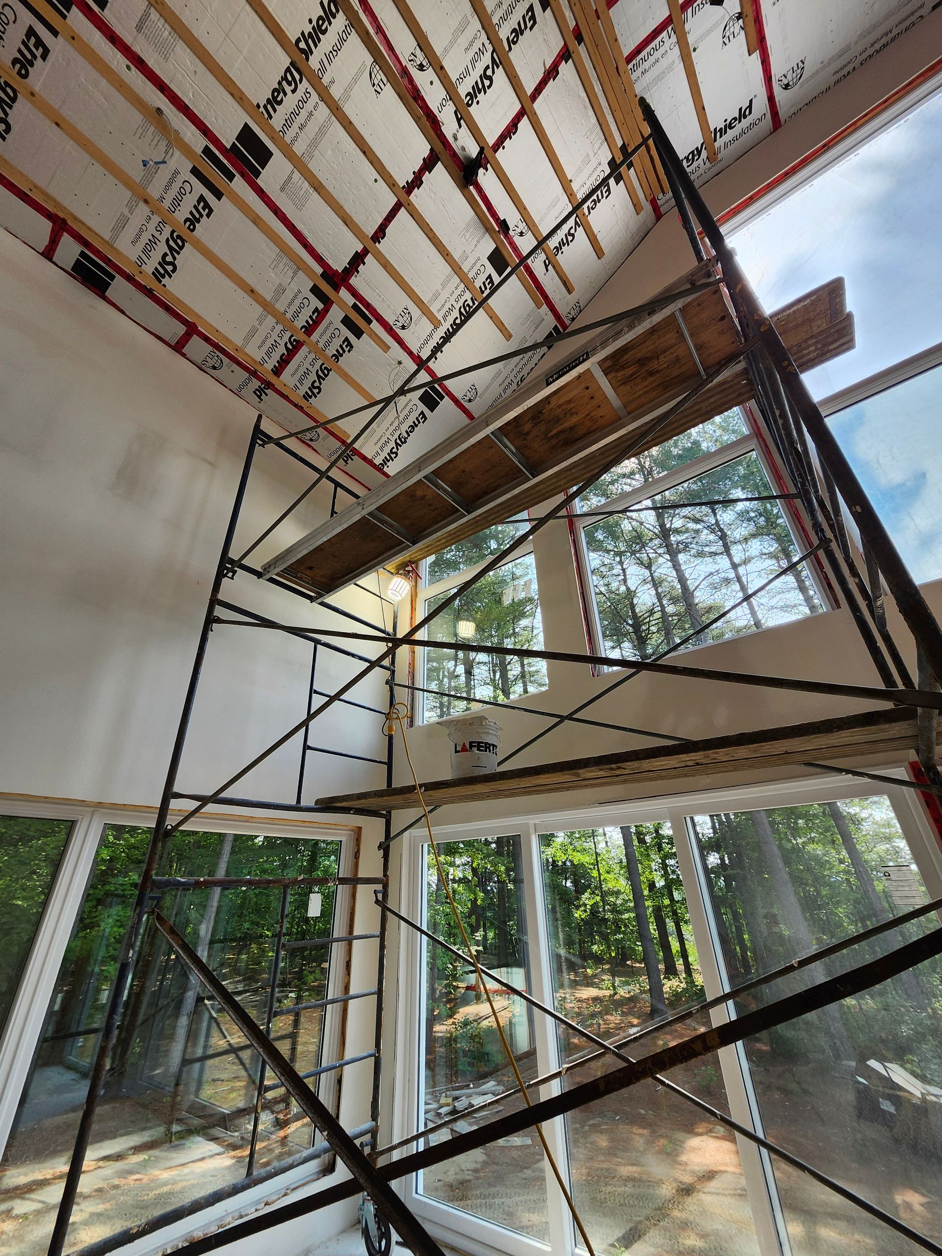 Il y a un échafaudage au milieu d'une pièce avec beaucoup de fenêtres.