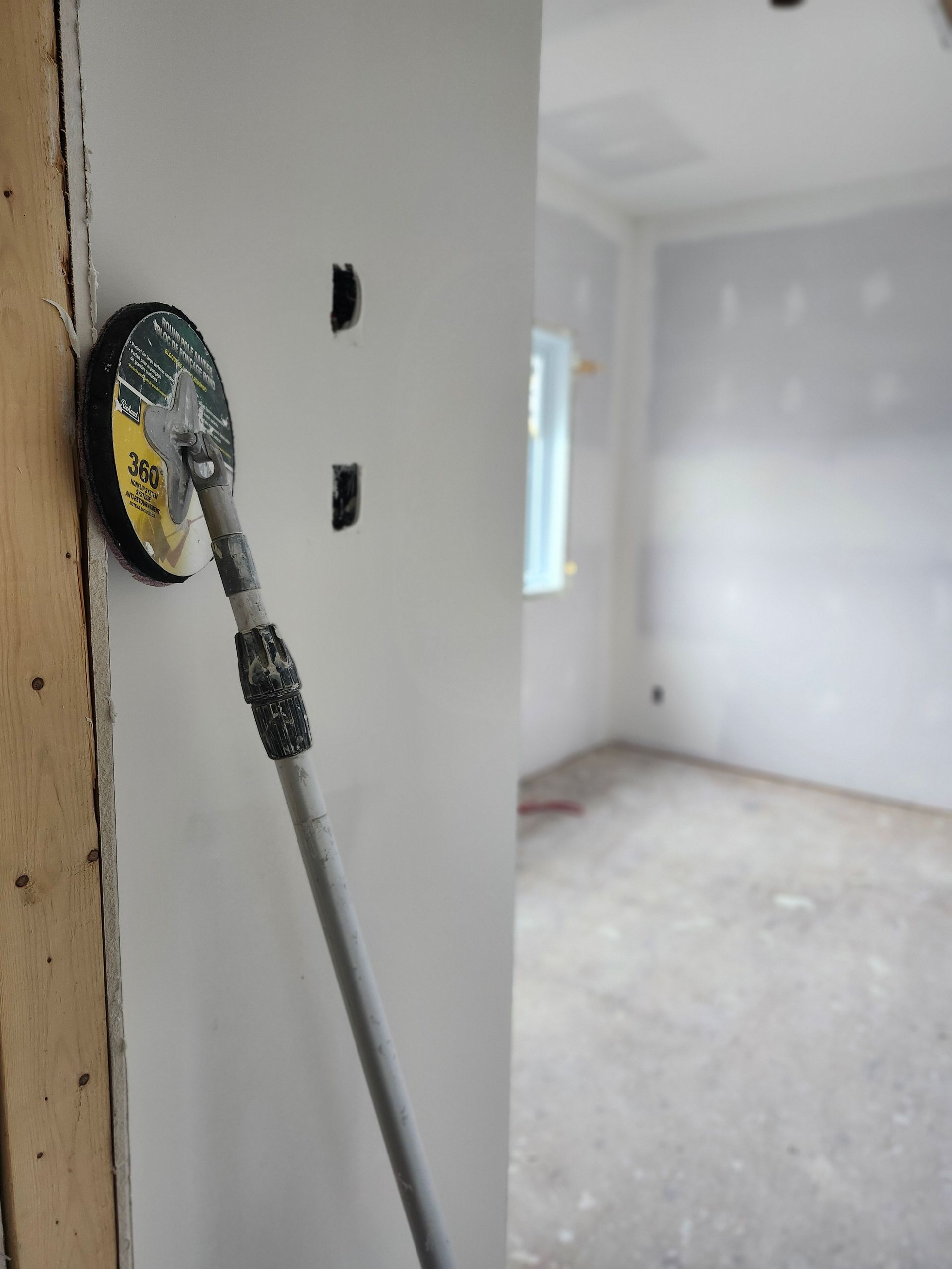 Une personne enduit un mur avec une truelle.