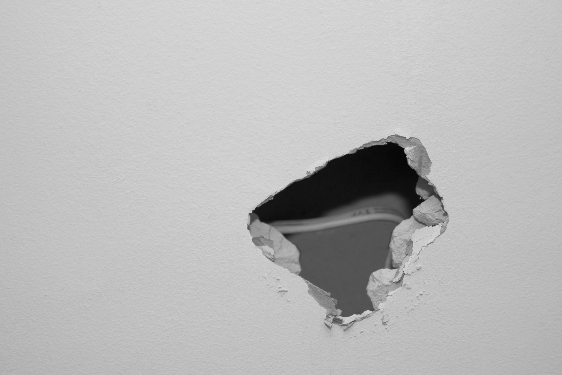 Une photo en noir et blanc d'un trou dans un mur