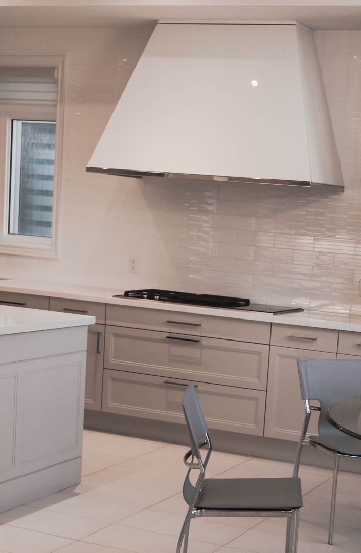 a kitchen with white cabinets and a stove top oven