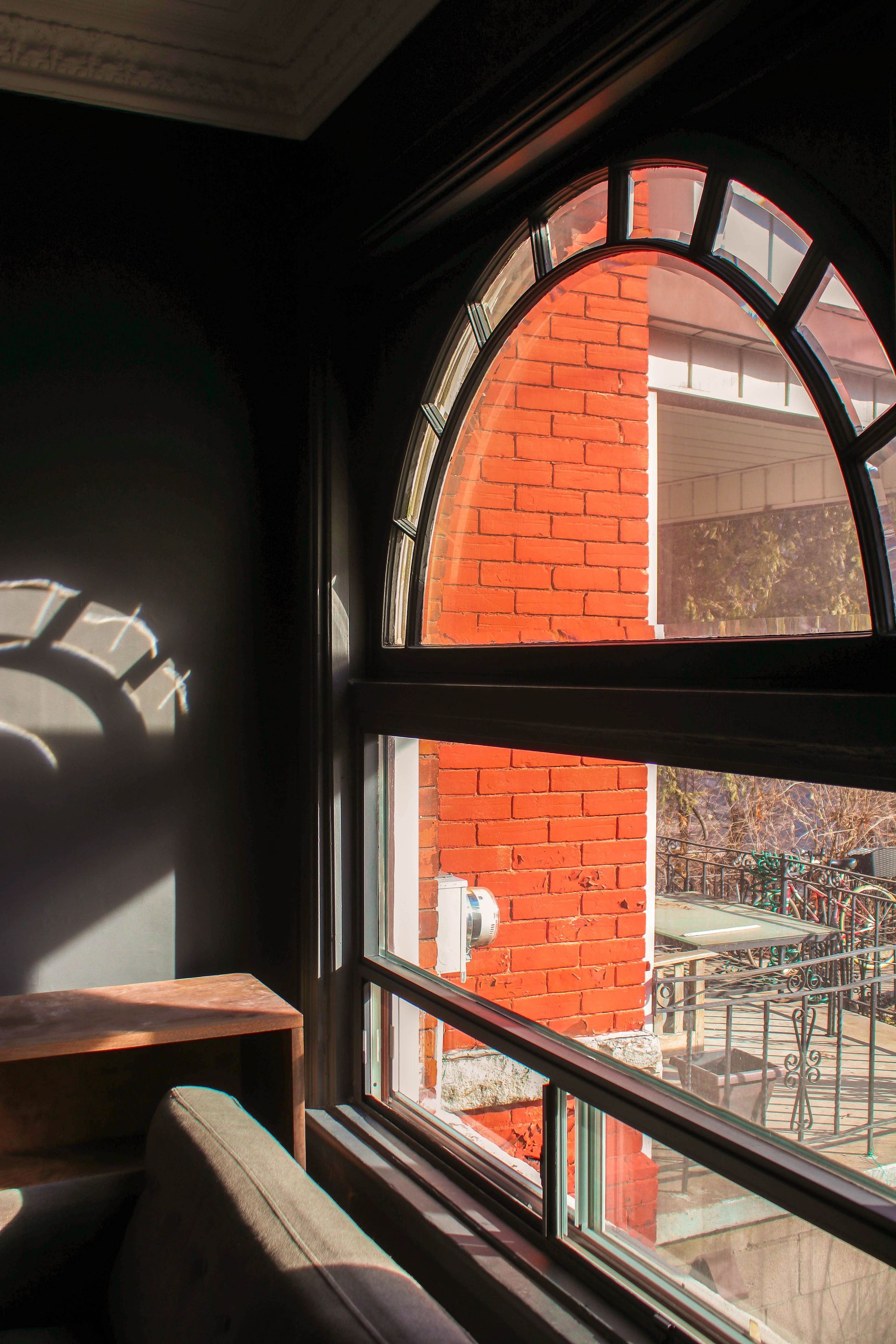 a room with a large window and a brick wall