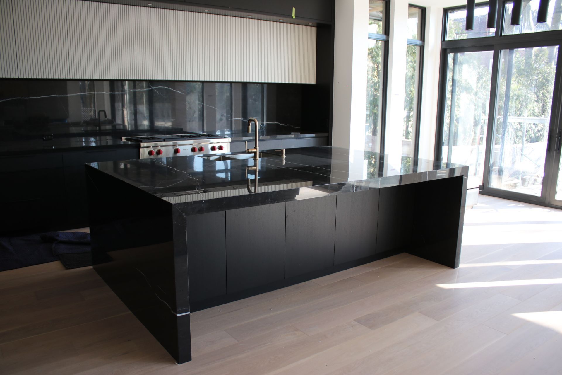 a kitchen with black cabinets and a large island in the middle