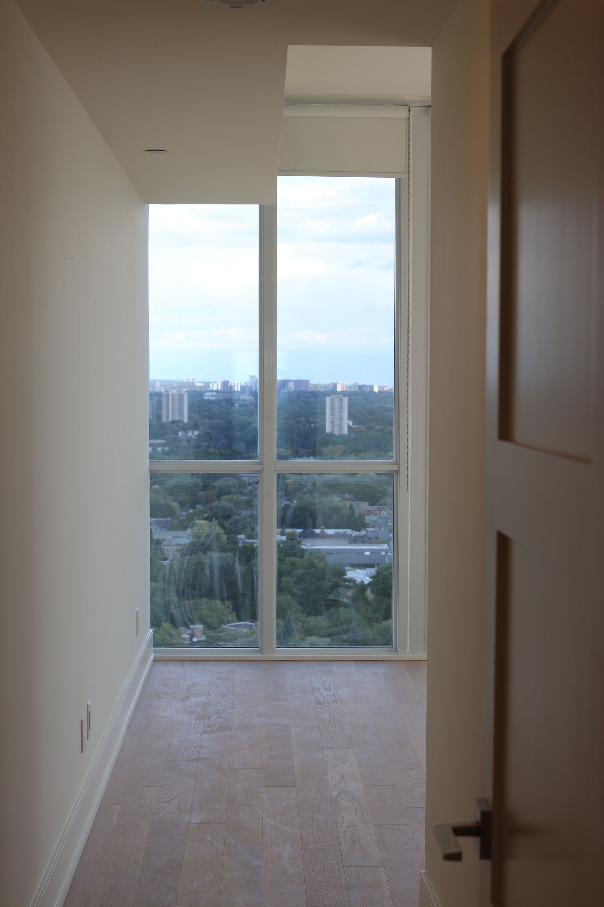 an empty room with a large window and a view of a city