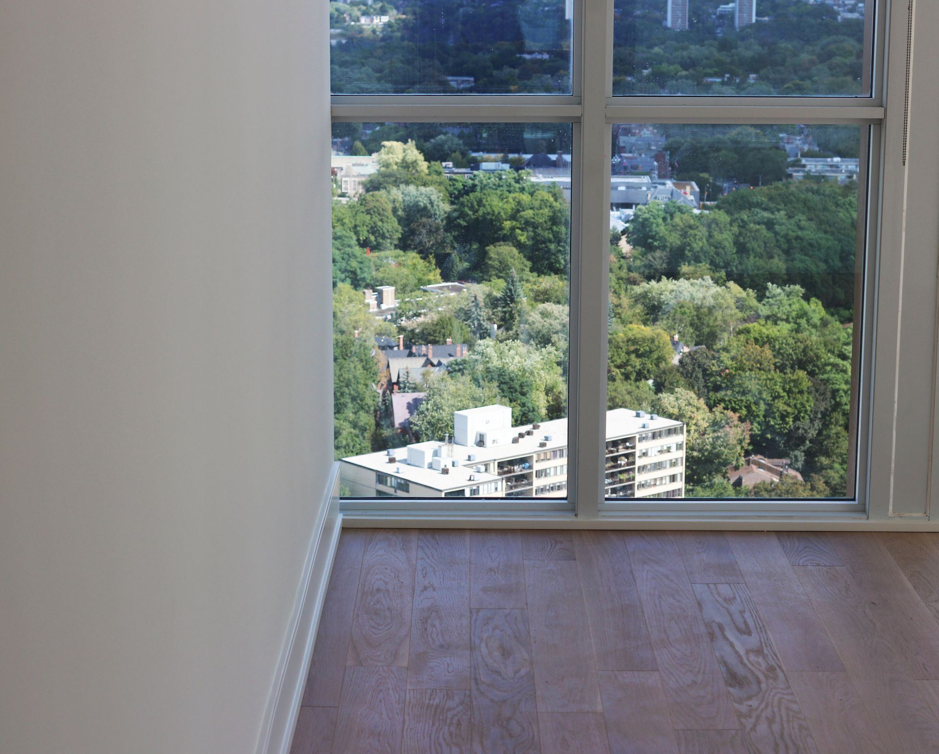 an empty room with a large window and a view of a city