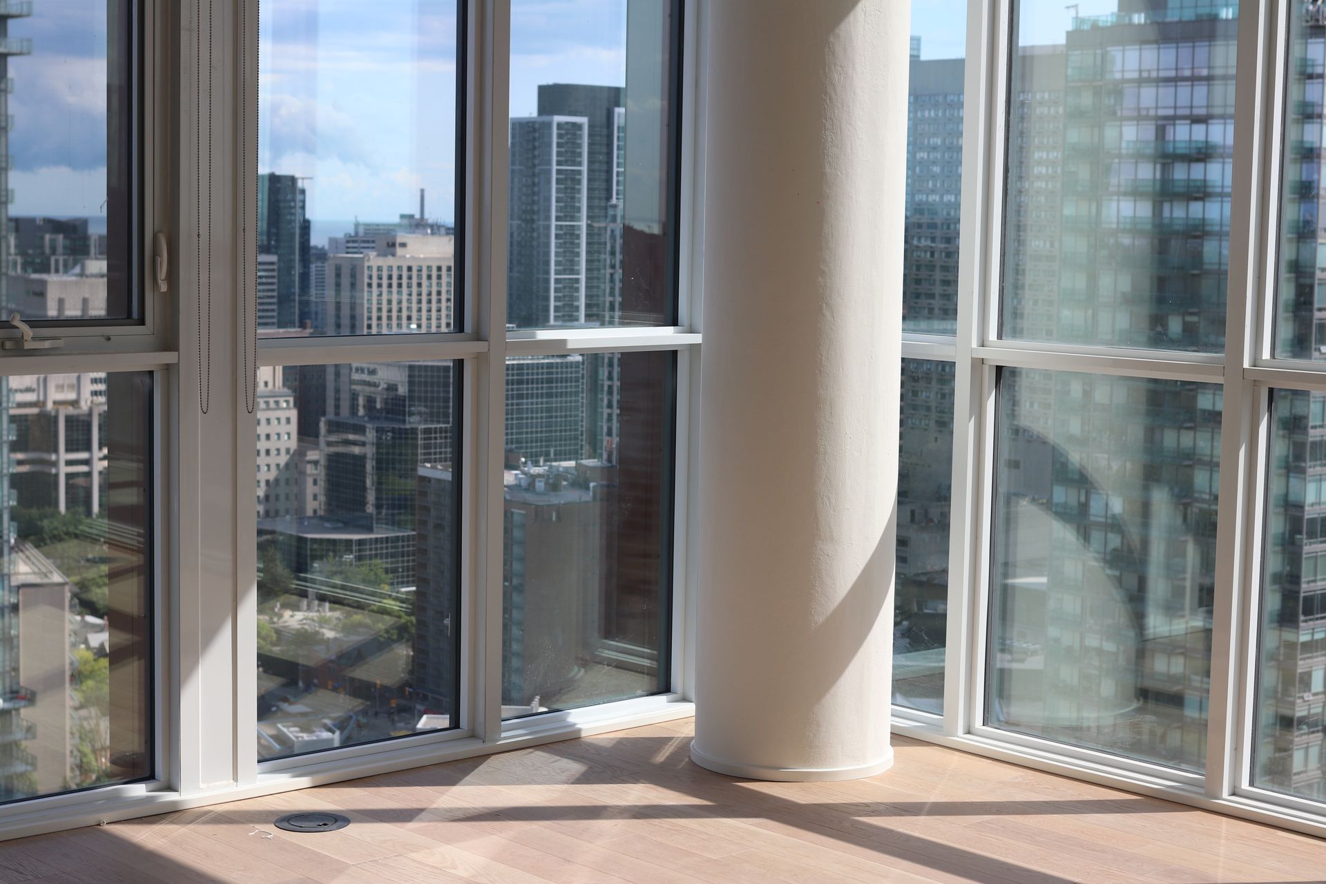 an empty room with a lot of windows and a view of the city