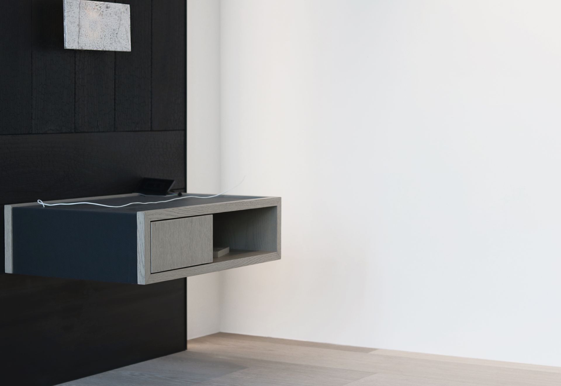 a floating nightstand is hanging on a wall in a room .