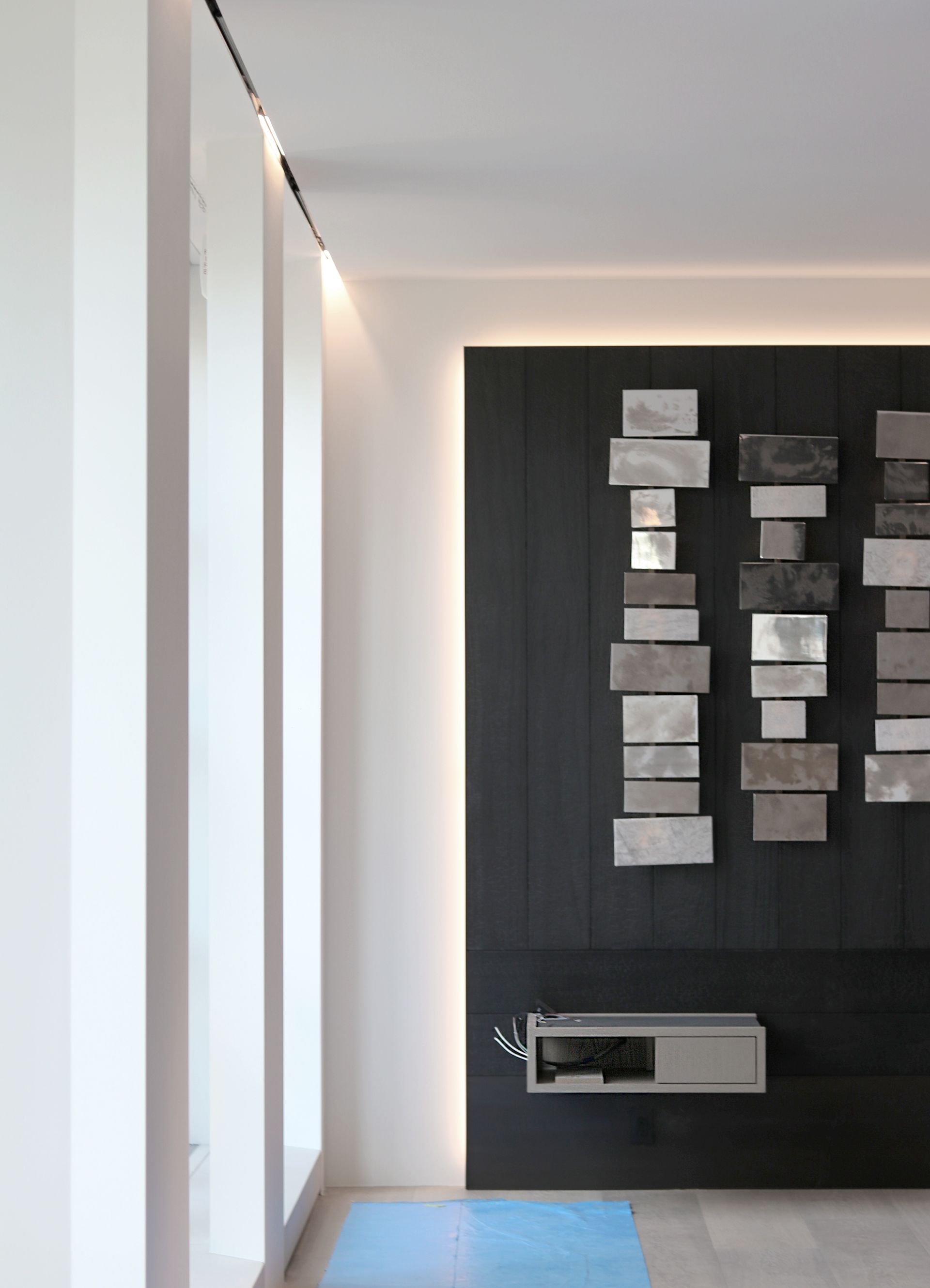 a living room with a black wall and a blue rug