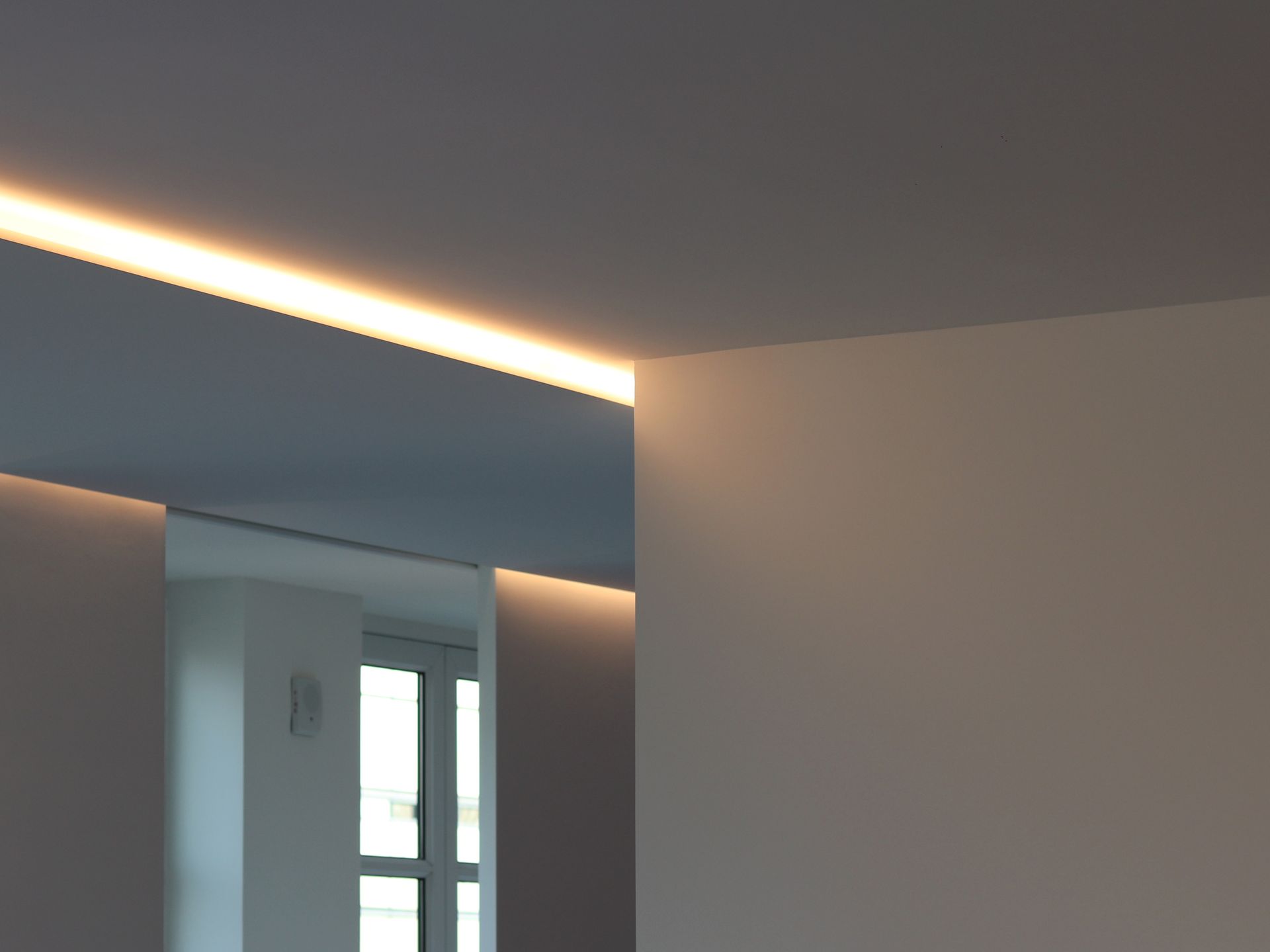 a corner of a room with a light on the ceiling