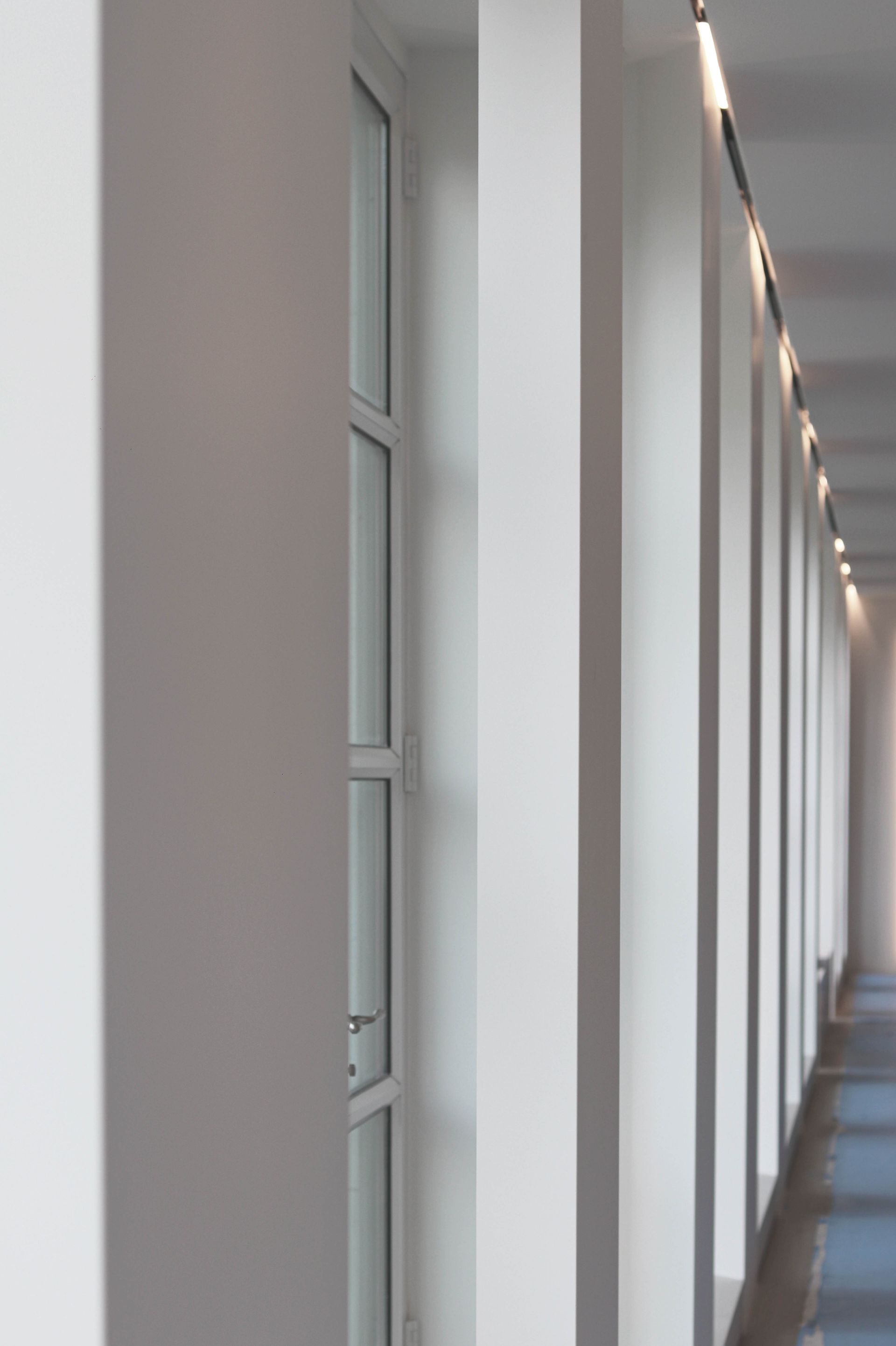 a long hallway with a lot of windows and columns .
