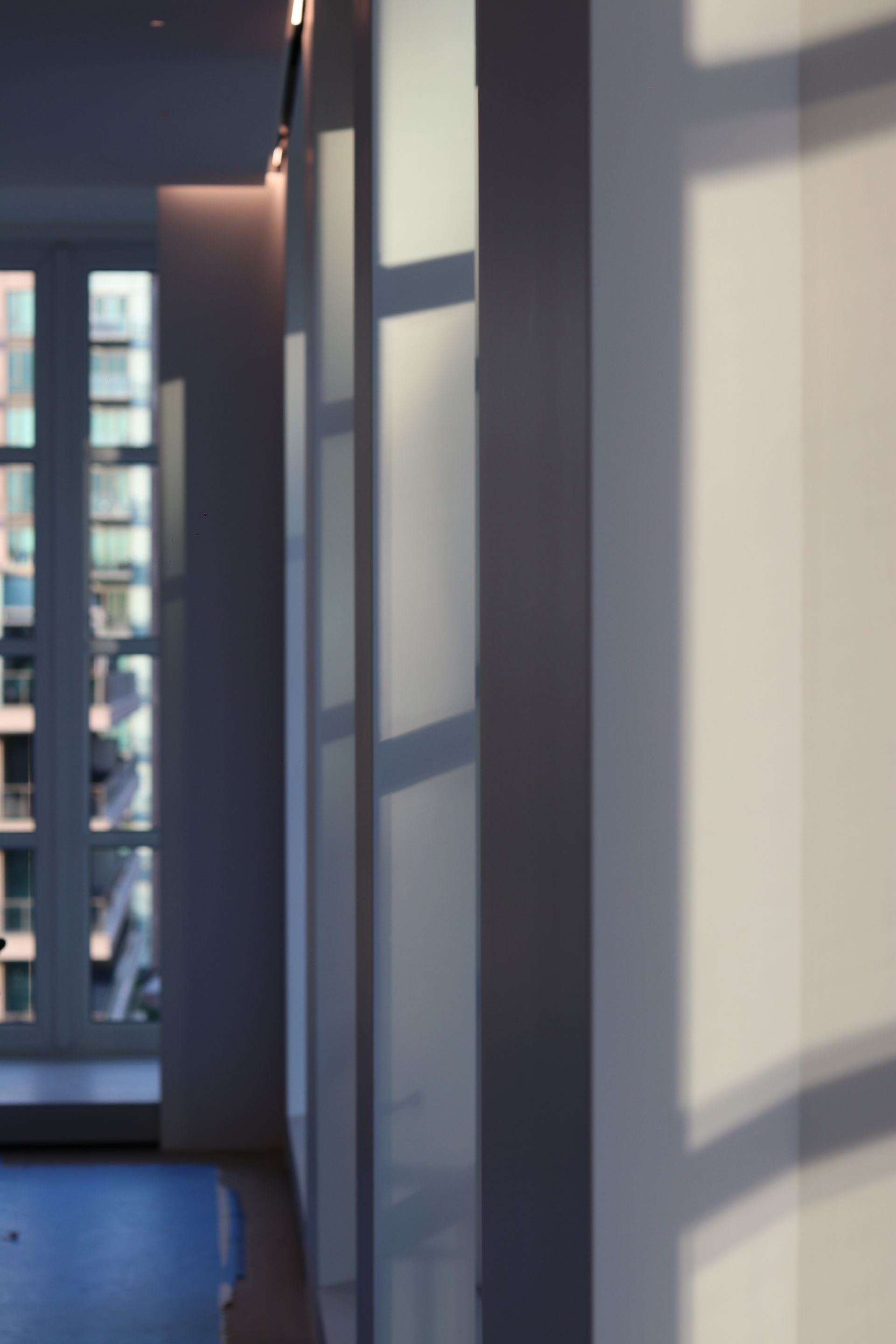 a hallway with a shadow of a window on the wall